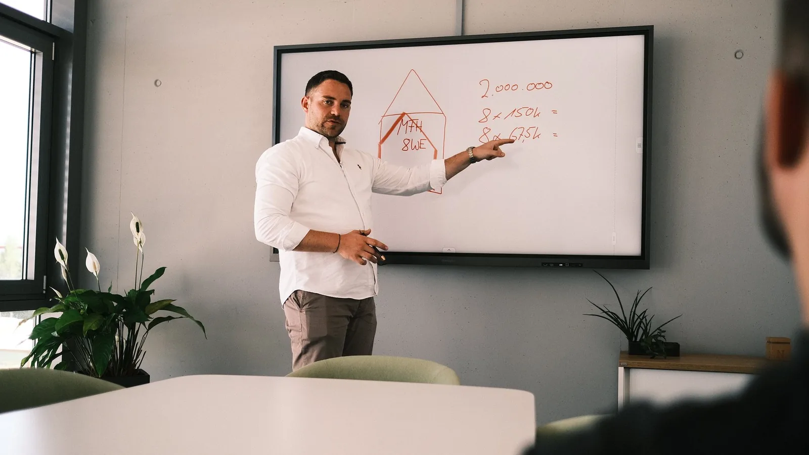 Sebastian Nafz erklärt am Whiteboard die Rechnung zu einem Immobilienprojekt
